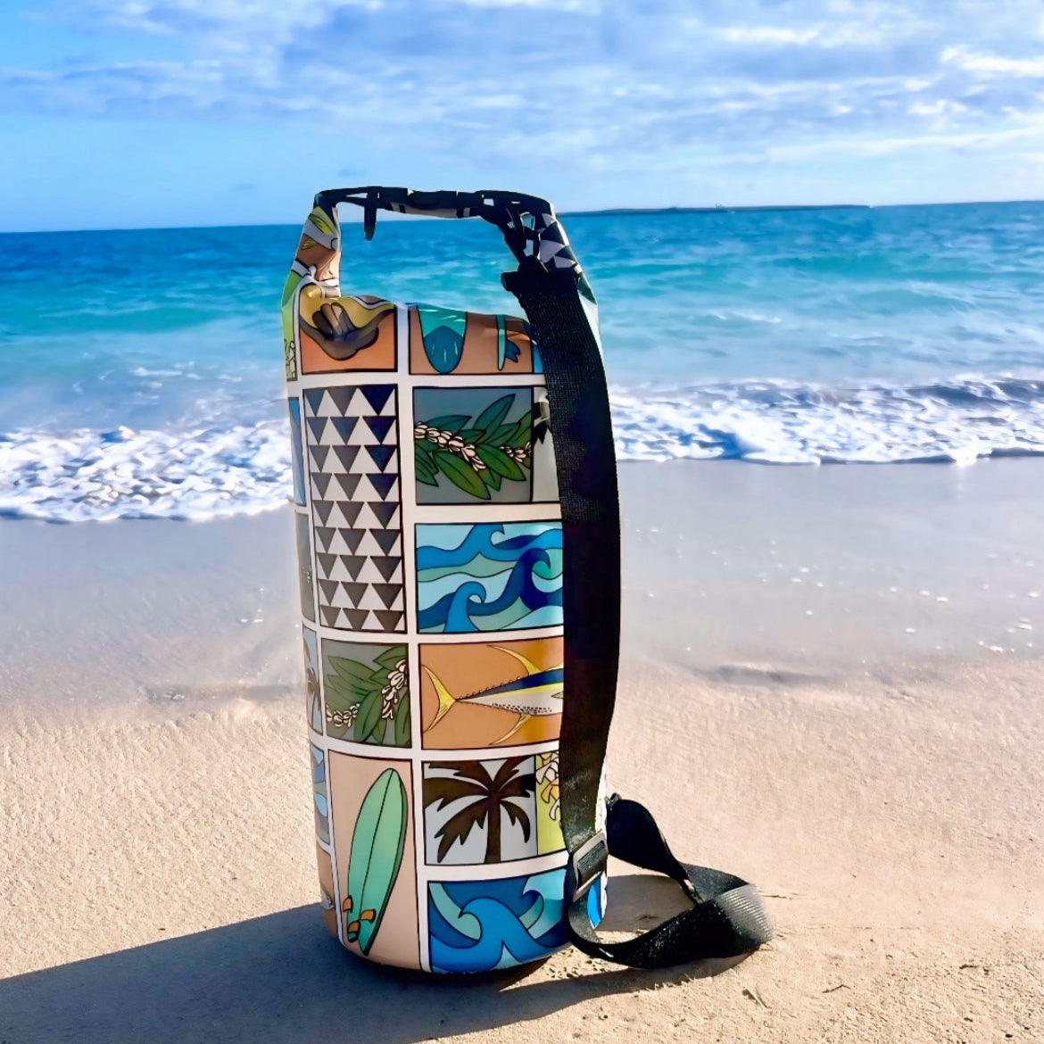 Decorative dry bag with tropical patterns on a sandy beach with ocean in the background